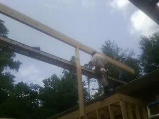 Carpenter setting a ridge beam over a new addition frame — Ice Dam Removal by Roofing Brothers in Pisgah