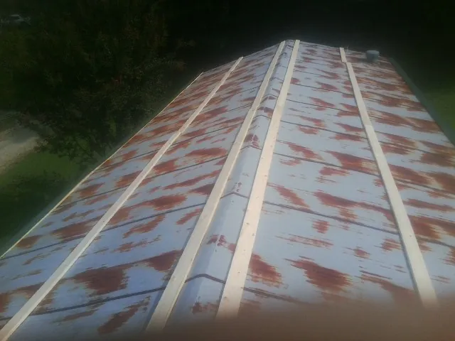Rusted metal roof panels with new wood purlins before replacement — Storm Damage Roof Repair in Pisgah by Roofing Brothers