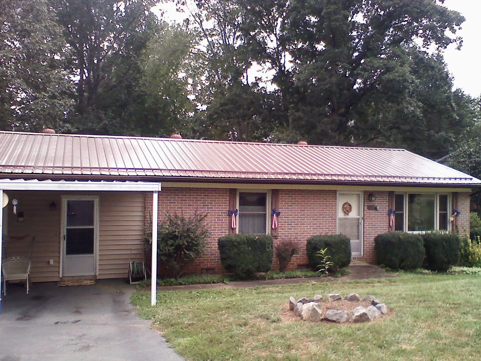 Bronze metal roof and carport on a brick ranch home — Roof Repair work by our crew in Pisgah